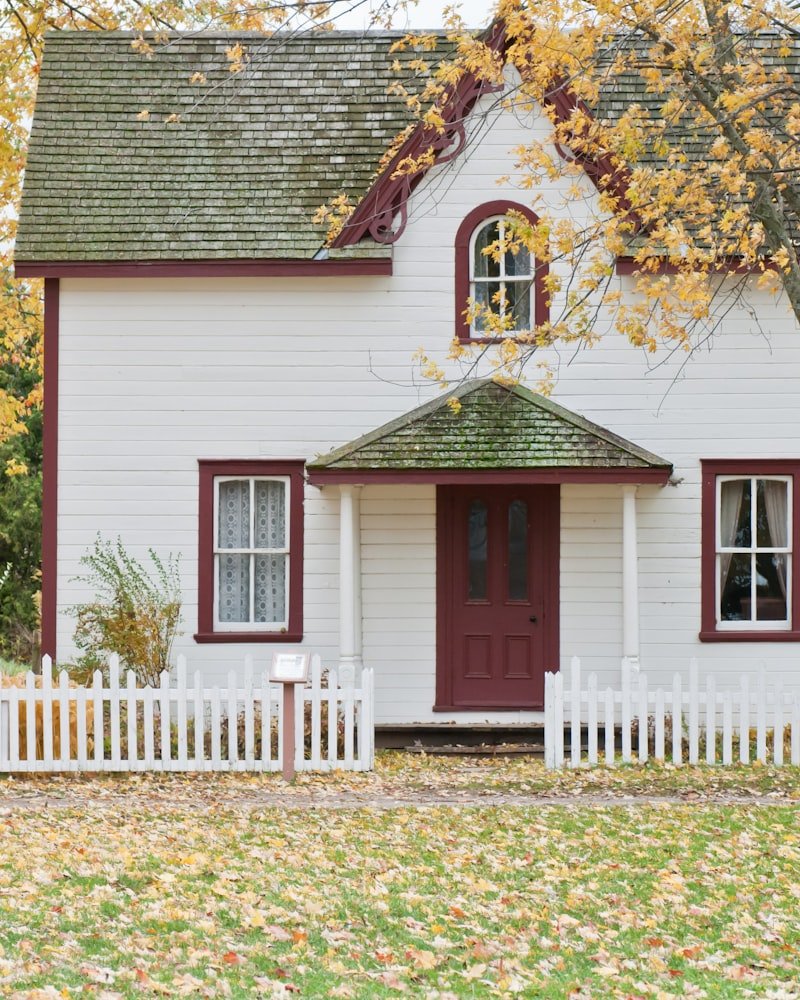 Maison résidentielle avec porte rouge aux feuilles d'automne — courtage hypothécaire Montréal